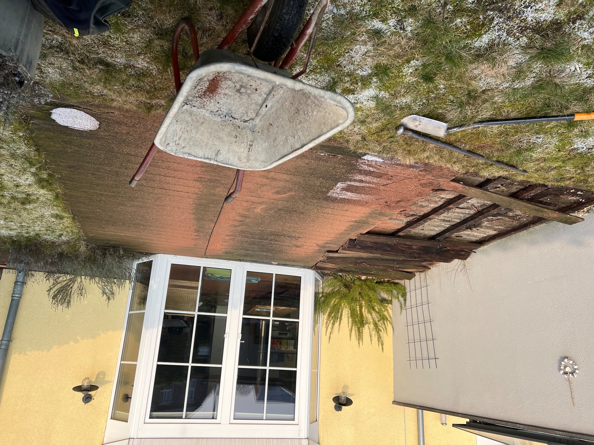 Alte Terrasse vor der Sanierung mit Schubkarre und Baustelle