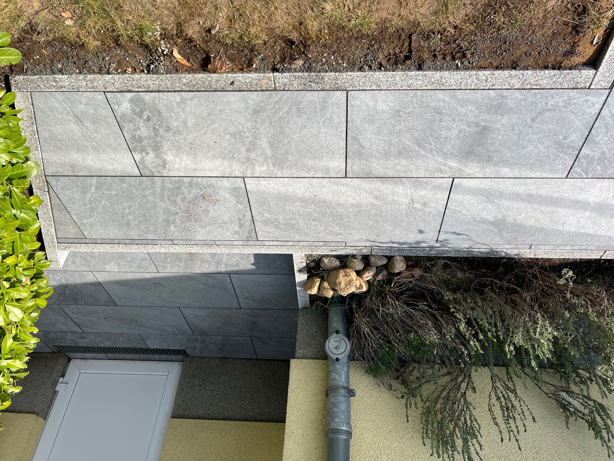 Detailansicht der verlegten Betonplatten mit Graniteinfassung