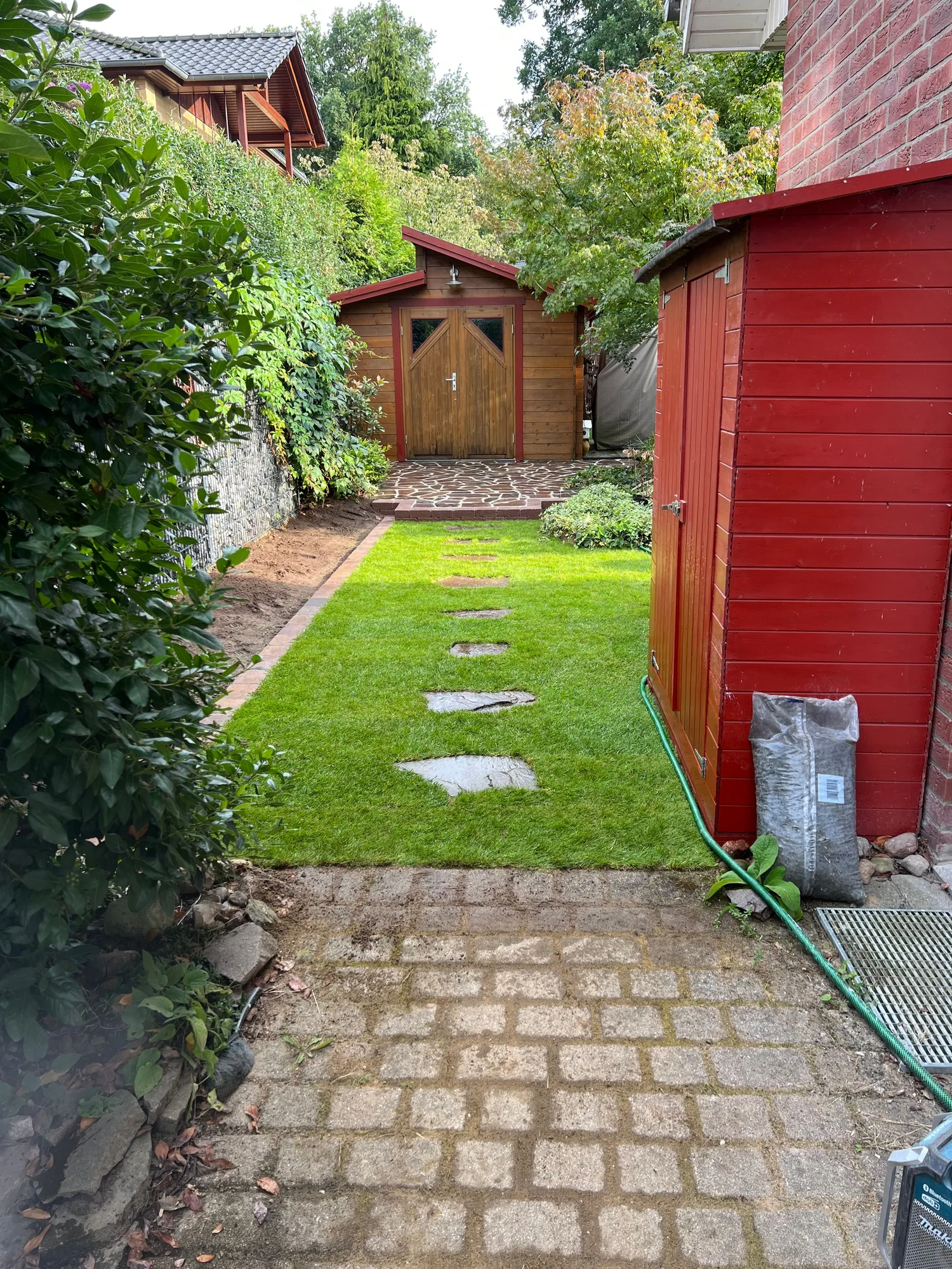 Rollrasen mit Naturstein-Trittplatten